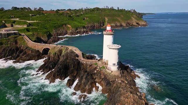 Drone flying towards Petit Minou Lighthouse on rocky islet, Brittany, France. Aerial forward