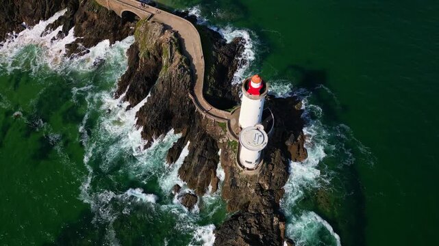 Petit Minou Lighthouse, waves crashing on rocky cliffs, Plouzan&eacute;, France. Aerial top-down backward