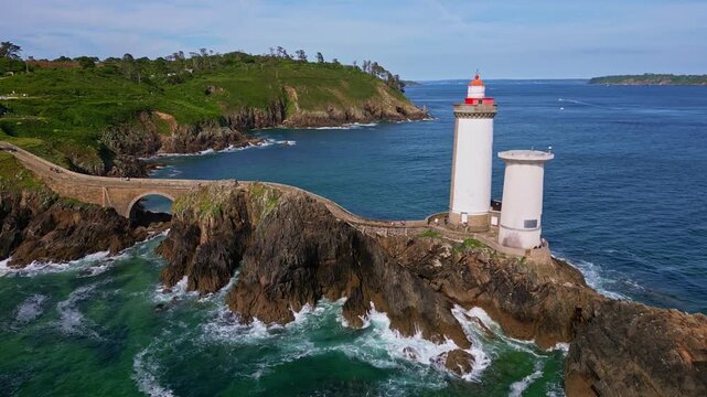Petit Minou Lighthouse on rocky islet, stone causeway, sea with waves, Plouzan&eacute;, Brittany, France. Aerial drone lateral view