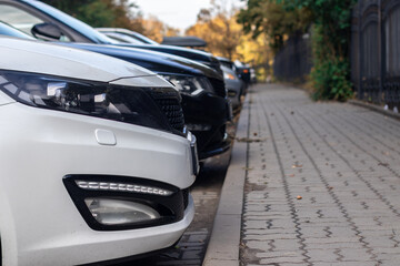 Parked cars standing in a row near a city park