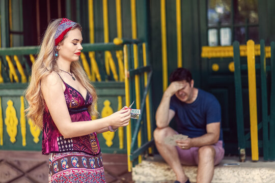 Gypsy fortune teller scam with woman taking money from client after tarot reading