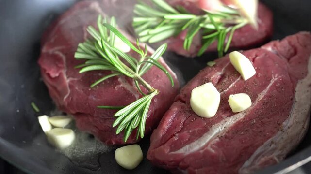 Beef steaks sprinkled with garlic and rosemary. The meat is deliciously cooked.
