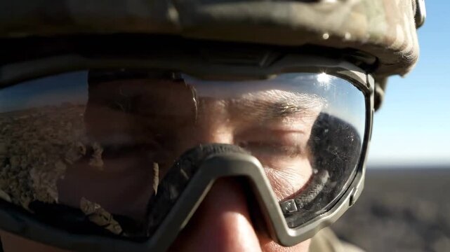 Close up of soldier wearing helmet and goggles looking forward.