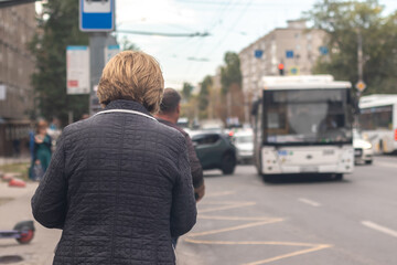 Woman standing on bus station waiting for a bus