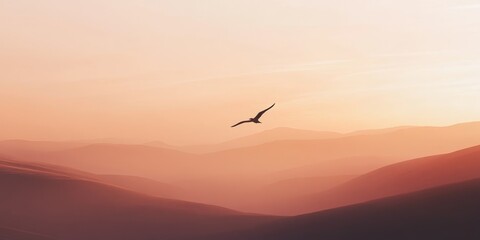Bird flying over a mountain range with a pink sky in the background