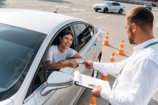 Congratulations giving the license, passed. Woman is trying to pass exam in the driving school