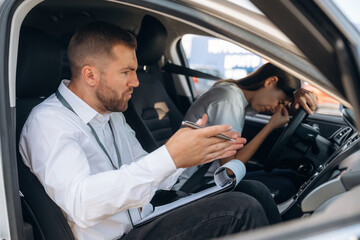 Failure concept, didn't pass. Woman is with instructor in car, driving school concept