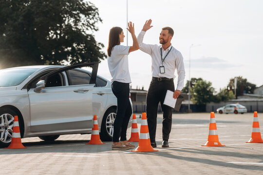 High five, you passed. Woman is trying to pass exam in the driving school
