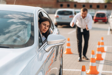 Naklejka premium Parking exercise. Woman is trying to pass exam in the driving school