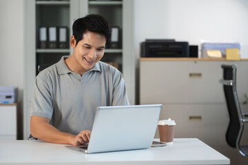 Fototapeta premium Businessman using laptop computer in office. Happy man, entrepreneur, small business owner working online.