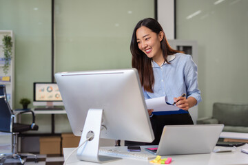 woman using mobile phone in modern office with laptop and digital tablet computer with VR icon diagram at office in morning light.
