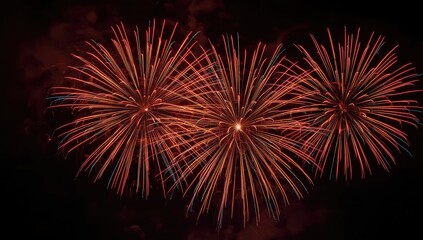 Three vibrant fireworks displays burst in the dark night sky, showcasing a spectacle of colors and light patterns.