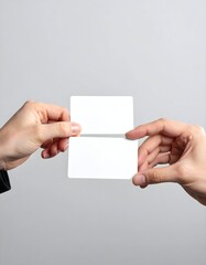 Two hands exchanging a blank double-sided business card against a light gray background