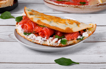 Crepe with salted trout fish and cream cheese on white table. Pancake made of rice flour and cottage cheese. Breakfast meal
