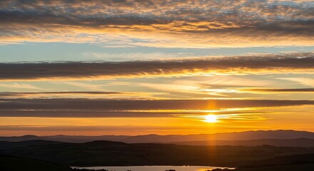 Stunning Sunset Over Water with Layered Clouds.