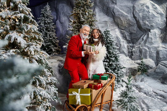 Joyful moments shared between a senior man and young woman during winter celebrations - Powered by Adobe