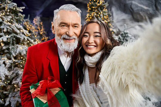 Joyful moments shared between a senior man and young woman in festive winter setting - Powered by Adobe
