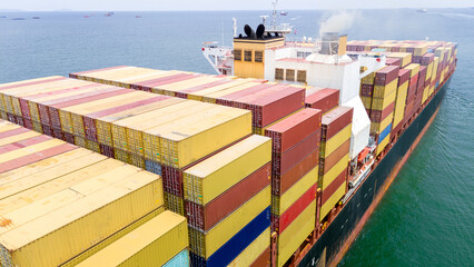 Stern of Cargo container ship carrying container and running in the ocean near international...