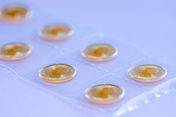 Close-up of 0.1  oz gold coins shining, wealth management, gold pricing, inflation hedge, investment in hard assets, gold ETFs.