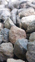 Detailed close-up macro shot of natural grey and brown stones, showcasing the rough, earthy texture of gravel for a geology-inspired abstract background