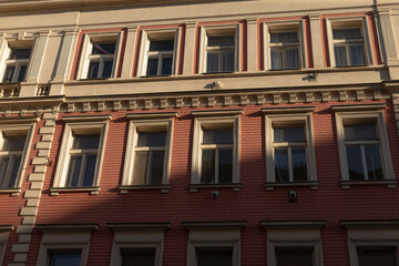 A historic building with a striking red facade and beautifully designed windows is showcased in this detailed view