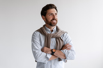 Confident man smiling looking aside with crossed arms
