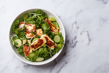 Cucumbers, sprouts and green leaves salad with fried halloumi.