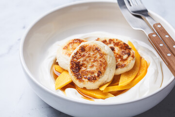 Homemade cottage cheese pancakes with yogurt and mango.