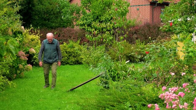 Elderly man in glasses slowly walking grouch a park enjoying retirement