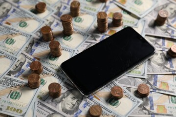 Smartphone, dollar banknotes and coins as background, closeup