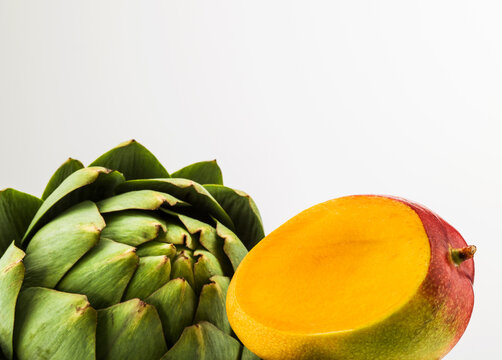 Still life of artichoke and mango.