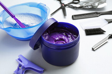 Hair care product for blonde hair and hairdresser's tools on white background, closeup