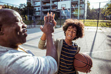 Grandfather and grandson playing basketball