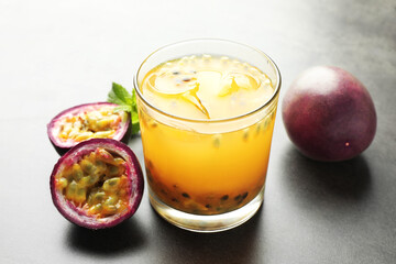 Tasty passion fruit drink with mint and fresh fruits on grey table, closeup