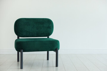 Stylish armchair near white wall in room, space for text
