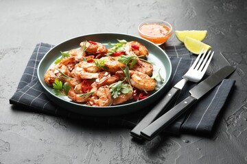 Tasty grilled shrimps with herbs and spices served on black table. Delicious seafood dish