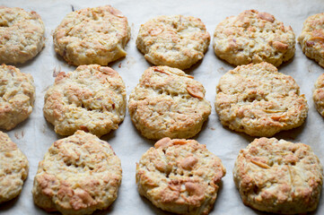 Finished oatmeal cookies lying on a sheet of parchment paper on a baking sheet. Baking at home. Delicious cookies for breakfast for children and adults. Dessert with milk, tea, or coffee.