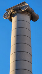 Stone column with Ionic capital detail illuminated by warm sunlight, symbolizing neoclassical architecture, heritage, culture and timeless European design.