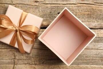 Opened gift box with beautiful lid on wooden table, top view