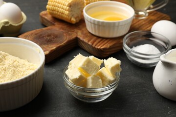 Making cornbread. Different ingredients on black textured table, closeup