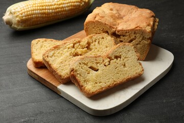 Freshly baked cornbread and cob on black table, closeup