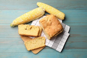 Freshly baked cornbread and cobs on light blue wooden table, flat lay