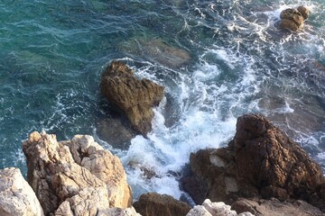 Sea with clean water and stones on shore in summer, above view