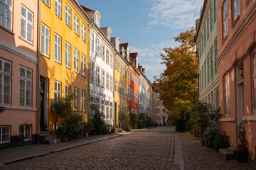 Obraz premium Street of colorful European houses, cobblestone road, soft morning light, eye-level shot