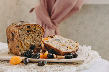 Healthy vegetarian gluten-free bread with cereals, prunes, dried apricots, nuts. Fresh baked bread on a board next to delicious cereals, grapes, prunes. Healthy food.