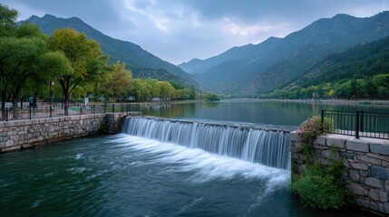 Hydroelectric Dam Waterfalls Flowing in Lake Surrounded by Forest Mountains Under Dramatic Cloudy Sky Tranquil Landscape in Nature Scenery Scenic View