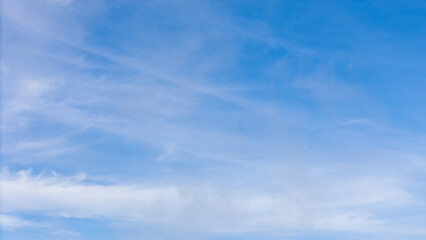 Fototapeta premium Clear blue sky with soft white clouds, perfect natural background for design, presentation, website, or environmental and weather-related concepts.