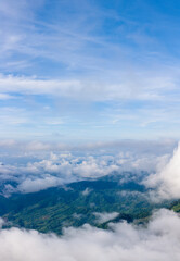 Aerial of Village in rain cloud cover tropical green mountain. Rainy season. Misty cover green forest. beautiful green village