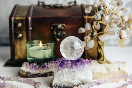 Gemstone crystal sphere or crystal balls known as crystallum orbis and orbuculum which is the beacon of peace and harmony in home environment. Natural clear quartz ball on amethyst geode in home.