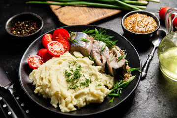 Herring with mashed potatoes tomatoes and mustard on a plate